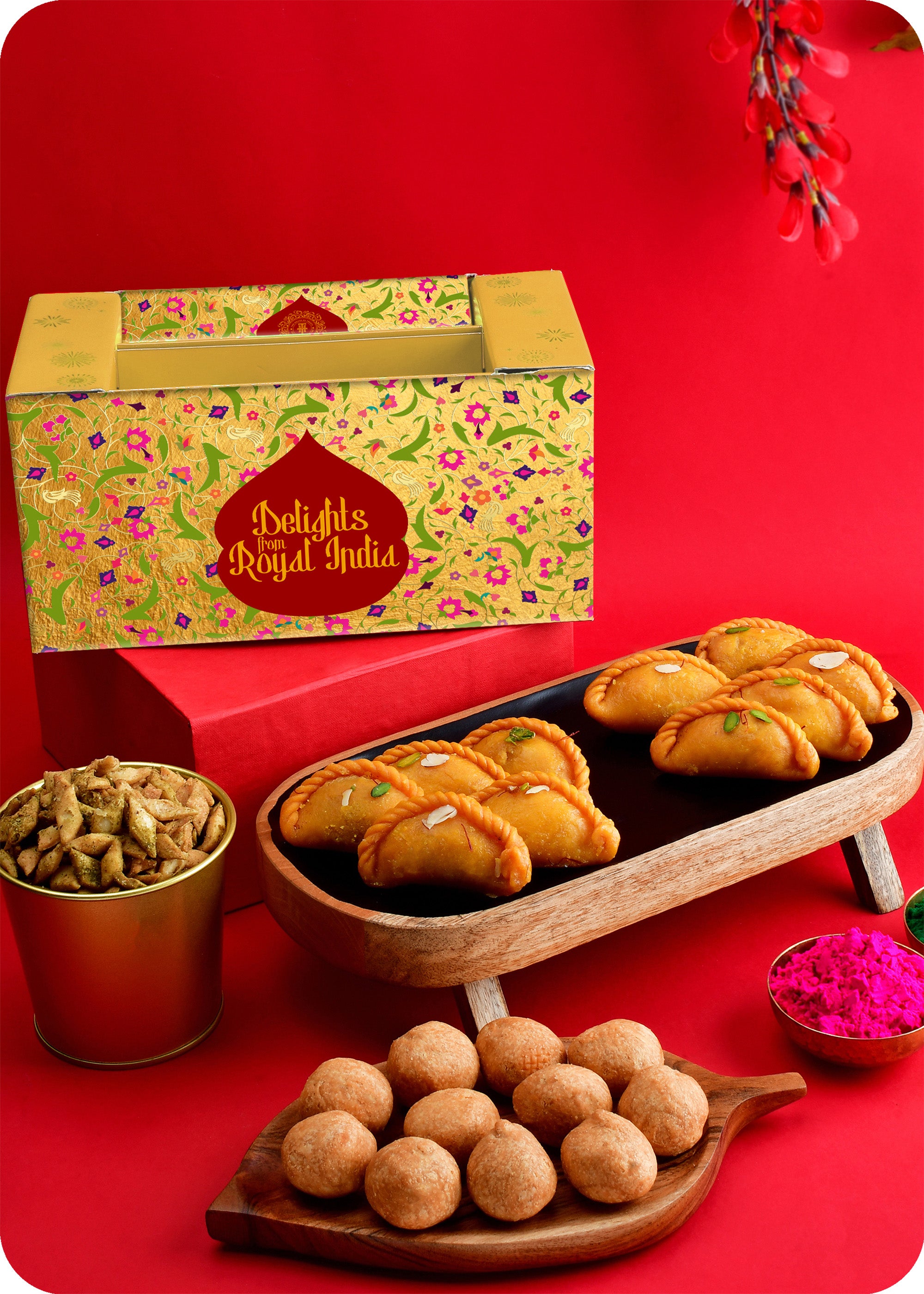 A Holi gift pack containing Shahi Gujiya, Pudhina Paare, Kachori and herbal gulal.