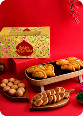 A colorful Holi gift pack consisting of sweets including gujiya, bhakarwadi, kachori and herbal gulal.