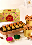 Holi sweets including Thandai Laddoo, Pan Laddoo, Samosa, and Bhakarwadi, and herbal gulal.