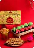 Colorful Holi gift pack including indian sweets rose chandrakala, pista chandrakala, methi sawali, khatta mittha mix and herbal gulal.