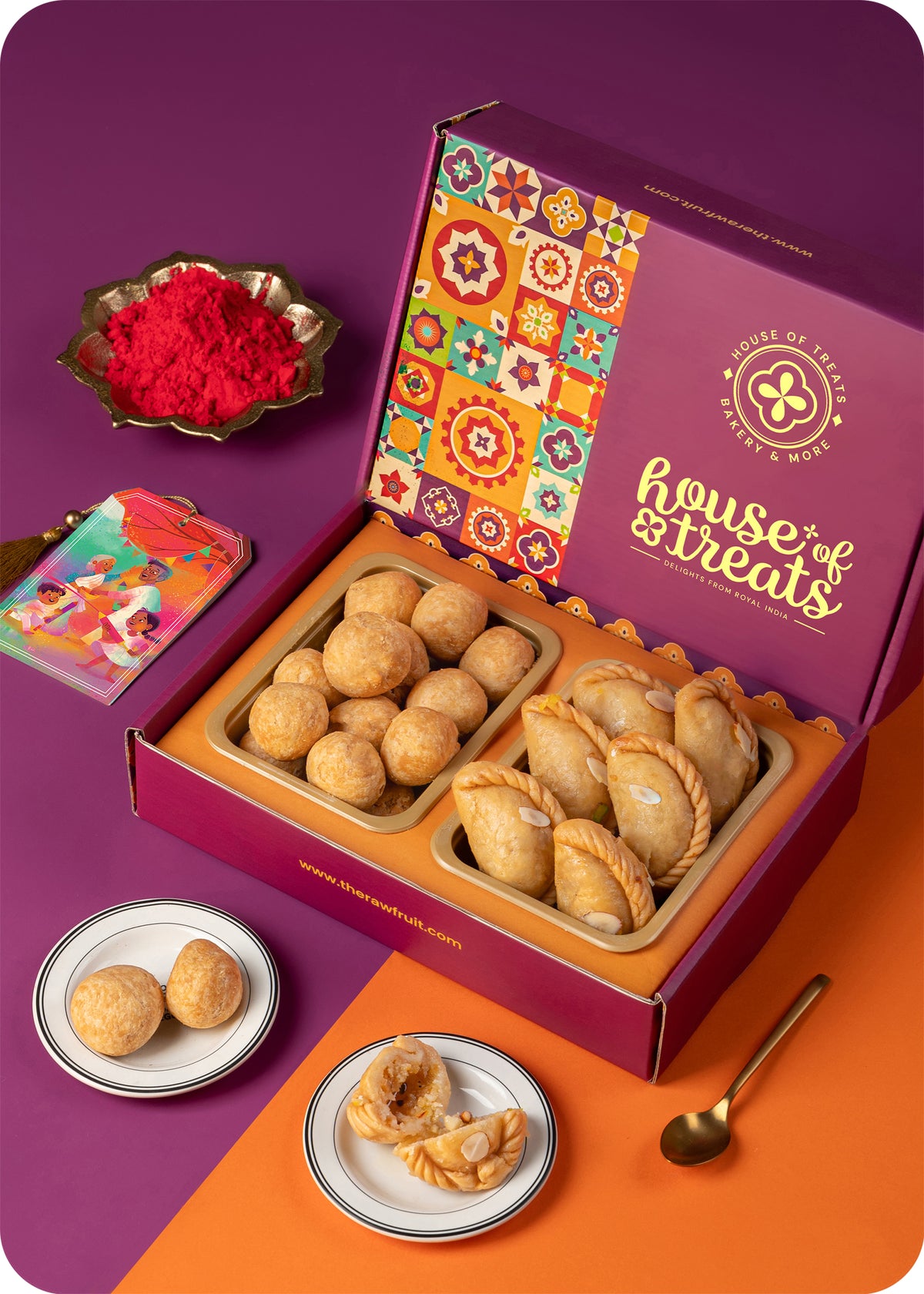 A colorful box of Holi sweets including gujiya, kachori, and herbal gulal.