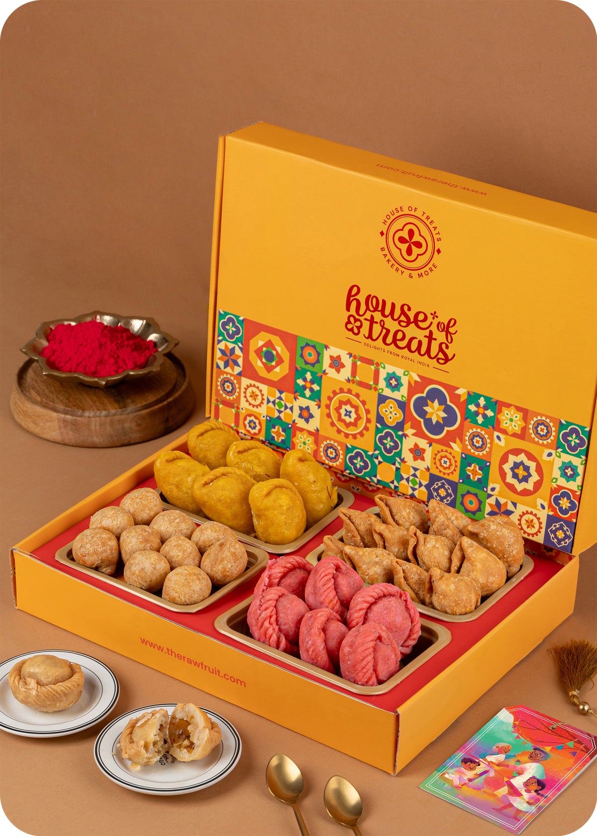 A colorful box of assorted Holi sweets and savory snacks, including rose chandrakala, kesar gujiya, samosa, kachori, and herbal gulal.